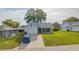 Street view of a single-story home featuring a driveway and well-kept front lawn at 8121 Casuarina Dr, Port Richey, FL 34668