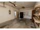 Spacious garage with storage shelves and a door to the outside, offering ample space for parking and organization at 8121 Casuarina Dr, Port Richey, FL 34668