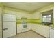 Functional kitchen boasts white appliances, tiled floors, and ample cabinet and counter space at 8121 Casuarina Dr, Port Richey, FL 34668