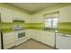 Well-lit kitchen features white appliances, updated countertops, and a stainless steel double sink at 8121 Casuarina Dr, Port Richey, FL 34668