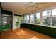 Bright sunroom with lots of light through large windows, ceiling fan, and door to backyard at 8121 Casuarina Dr, Port Richey, FL 34668