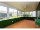 Sunroom surrounded by windows, bringing the outside in, with green wainscoting and wood-look floors at 8121 Casuarina Dr, Port Richey, FL 34668