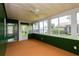 Bright sunroom with lots of light through large windows, ceiling fan, and door to backyard at 8121 Casuarina Dr, Port Richey, FL 34668