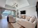 Bright living room featuring neutral tones, a ceiling fan, and large windows providing natural light at 8132 Capstone Ranch Dr, New Port Richey, FL 34655