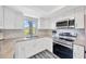 Bright kitchen featuring white cabinets, stainless steel appliances, and granite countertops at 8626 White Springs Dr, New Port Richey, FL 34655