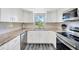 Modern kitchen with white cabinets, stainless steel appliances, and granite countertops at 8626 White Springs Dr, New Port Richey, FL 34655