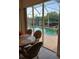 Bright dining space with views of the sparkling outdoor pool at 8630 Ne Coral Creek Loop, Hudson, FL 34667