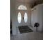 Bright and inviting foyer with white tile flooring, a decorative rug, and double doors with ornate glass details at 8630 Ne Coral Creek Loop, Hudson, FL 34667
