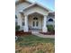 Home's front entrance with a paved walkway, white columns, double doors, and a small sitting area on the porch at 8630 Ne Coral Creek Loop, Hudson, FL 34667