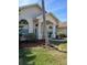 Front of the home featuring a palm tree in the yard, a well-manicured lawn, and a charming entrance at 8630 Ne Coral Creek Loop, Hudson, FL 34667