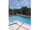 Refreshing screened pool with clear blue water, surrounded by lush greenery and a serene backyard at 8630 Ne Coral Creek Loop, Hudson, FL 34667