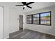 Bedroom featuring gray floors, neutral walls, ceiling fan and a window with a view at 9032 Dorsey St, Spring Hill, FL 34608