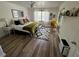 Bedroom featuring hardwood floors, a ceiling fan, a window, artwork on the walls, and a door to another room at 9485 Hamlin Blvd # 8, Seminole, FL 33776
