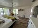 Primary bedroom has hardwood floors, a ceiling fan, a window, a door to the bathroom, and a sliding glass door to the porch at 9485 Hamlin Blvd # 8, Seminole, FL 33776