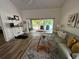 Comfortable living room area features hardwood flooring, an open sliding glass door to the screened porch, and a sofa at 9485 Hamlin Blvd # 8, Seminole, FL 33776