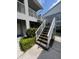 Exterior stairwell featuring white railings and mature landscaping at 9485 Hamlin Blvd # 8, Seminole, FL 33776