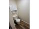 The toilet area of the bathroom has wooden-look flooring and a white cabinet installed above the toilet at 9485 Hamlin Blvd # 8, Seminole, FL 33776