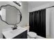 Clean bathroom featuring a single vanity, a decorative mirror, and a shower with a black curtain at 10623 Marsha Dr, New Port Richey, FL 34655