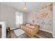 Charming Bedroom with a floral wallpaper, wood floors, and a cozy toddler bed at 10623 Marsha Dr, New Port Richey, FL 34655