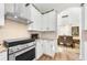 Well-appointed kitchen with stainless steel appliances, white cabinetry, and an open view to the dining area at 10623 Marsha Dr, New Port Richey, FL 34655