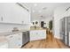 Bright kitchen featuring white cabinets, stainless steel appliances, granite counters, and hardwood floors at 10623 Marsha Dr, New Port Richey, FL 34655