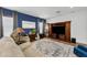Cozy living room with blue accent wall, decorative rug and large, dark wood entertainment center at 10623 Marsha Dr, New Port Richey, FL 34655