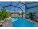 Relaxing screened-in pool area with refreshing blue water, brick pavers, and lush plants for a private oasis at 10623 Marsha Dr, New Port Richey, FL 34655