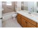 Neutral-toned bathroom with a bath tub, tile floor, and solid surface vanity with traditional cabinetry at 11001 Peppertree Ln, Port Richey, FL 34668