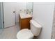Cozy powder room with toilet, vanity, and tile flooring at 11001 Peppertree Ln, Port Richey, FL 34668