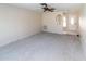 Bright living room features a ceiling fan and a view into entry hallway, ready for your personal touch at 11001 Peppertree Ln, Port Richey, FL 34668