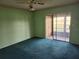 Spacious bedroom with blue carpet flooring and a sliding glass door to the patio at 11130 Carriage Hill Dr # 1, Port Richey, FL 34668