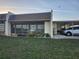 Single story home with a long carport and a screened in front porch lined with flower beds at 11130 Carriage Hill Dr # 1, Port Richey, FL 34668