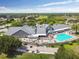 Beautiful aerial view of a clubhouse with a swimming pool and golf course in a lush green community at 11339 Alden Ct, Hudson, FL 34667