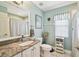 Bright bathroom features a marble vanity countertop, decorative mirror, and coordinating shower curtain at 11339 Alden Ct, Hudson, FL 34667