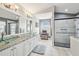 Bathroom featuring a marble vanity countertop, glass sinks, walk-in shower and large mirror at 11339 Alden Ct, Hudson, FL 34667
