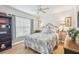 Comfortable bedroom boasts a ceiling fan, wood floors, window with blinds and a decorative floral comforter at 11339 Alden Ct, Hudson, FL 34667
