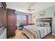 Spacious bedroom features a wooden bed frame, desk area, ceiling fan, and a window view at 11339 Alden Ct, Hudson, FL 34667