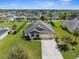 Expansive aerial view of a home with lush green lawns, mature trees, and a three-car garage in a lovely neighborhood at 1155 Buckhurst Dr, Spring Hill, FL 34609