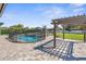 Spacious backyard featuring a fenced pool, a firepit, and manicured landscape at 1155 Buckhurst Dr, Spring Hill, FL 34609