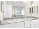 Bathroom featuring double vanity, granite countertops, large mirror, and a shower at 1155 Buckhurst Dr, Spring Hill, FL 34609