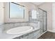 Bright bathroom with a large tub, mosaic tile accents, and frameless glass shower at 1155 Buckhurst Dr, Spring Hill, FL 34609
