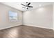 Well-lit bedroom featuring a ceiling fan, hardwood floors, and a window at 1155 Buckhurst Dr, Spring Hill, FL 34609