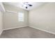 Empty bedroom with neutral carpet, ceiling fan, and natural light streaming in from the window at 1155 Buckhurst Dr, Spring Hill, FL 34609
