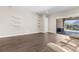 Bright living room with hardwood floors, access to the patio, and three floating shelves at 1155 Buckhurst Dr, Spring Hill, FL 34609