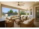 Covered patio featuring comfortable seating, ceiling fans, and views of the inviting pool and backyard at 1155 Buckhurst Dr, Spring Hill, FL 34609