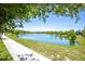 Picturesque community lake view with lush green grass, mature trees, and a sidewalk at 12266 Barn Cat Run, Odessa, FL 33556