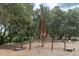 Unique playground equipment with rope climbing structures, elevated platforms, and a wood chip ground cover, perfect for outdoor play at 12266 Barn Cat Run, Odessa, FL 33556