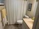 Bathroom with a toilet, sink, and shower-tub combination behind a patterned curtain at 12330 Comstock St, Spring Hill, FL 34609