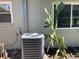 Exterior home featuring air conditioning unit with cactus, and two windows at 12330 Comstock St, Spring Hill, FL 34609