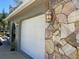 Exterior view of the garage with an attached stone accent wall and decorative lighting at 12330 Comstock St, Spring Hill, FL 34609